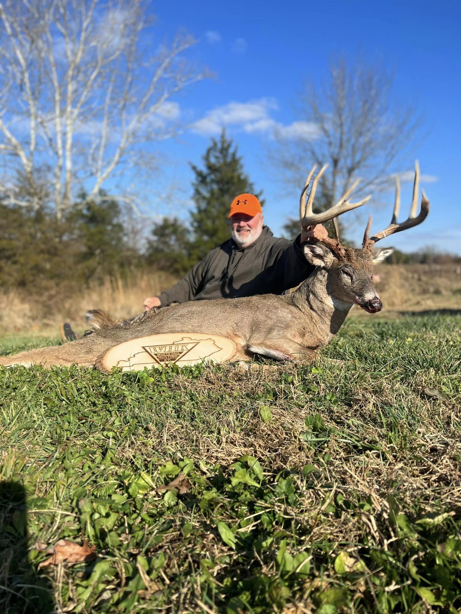 Hunter smiles proudly with a large buck harvested on property.
